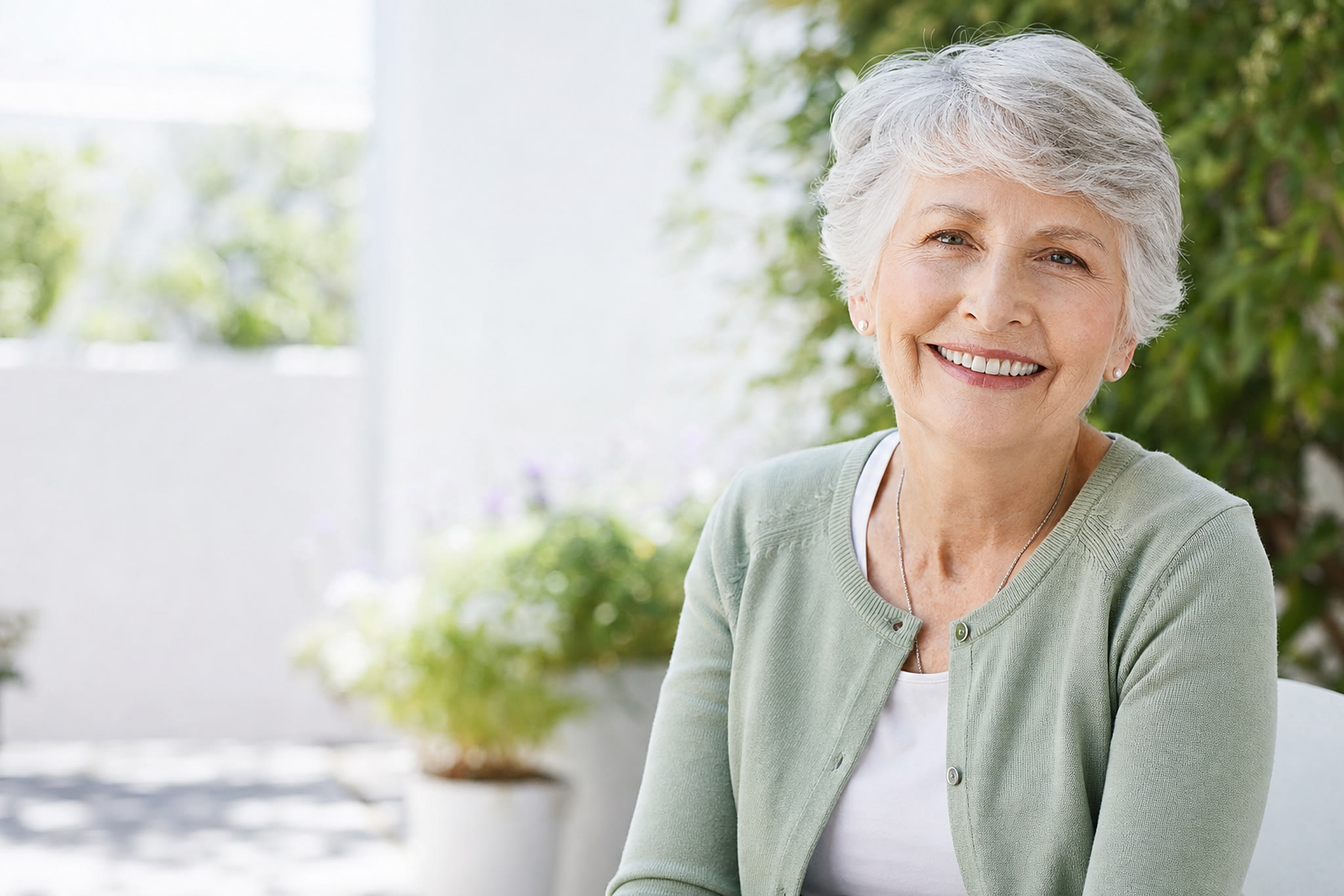 Une femme souriant chaleureusement dans un jardin ensoleillé