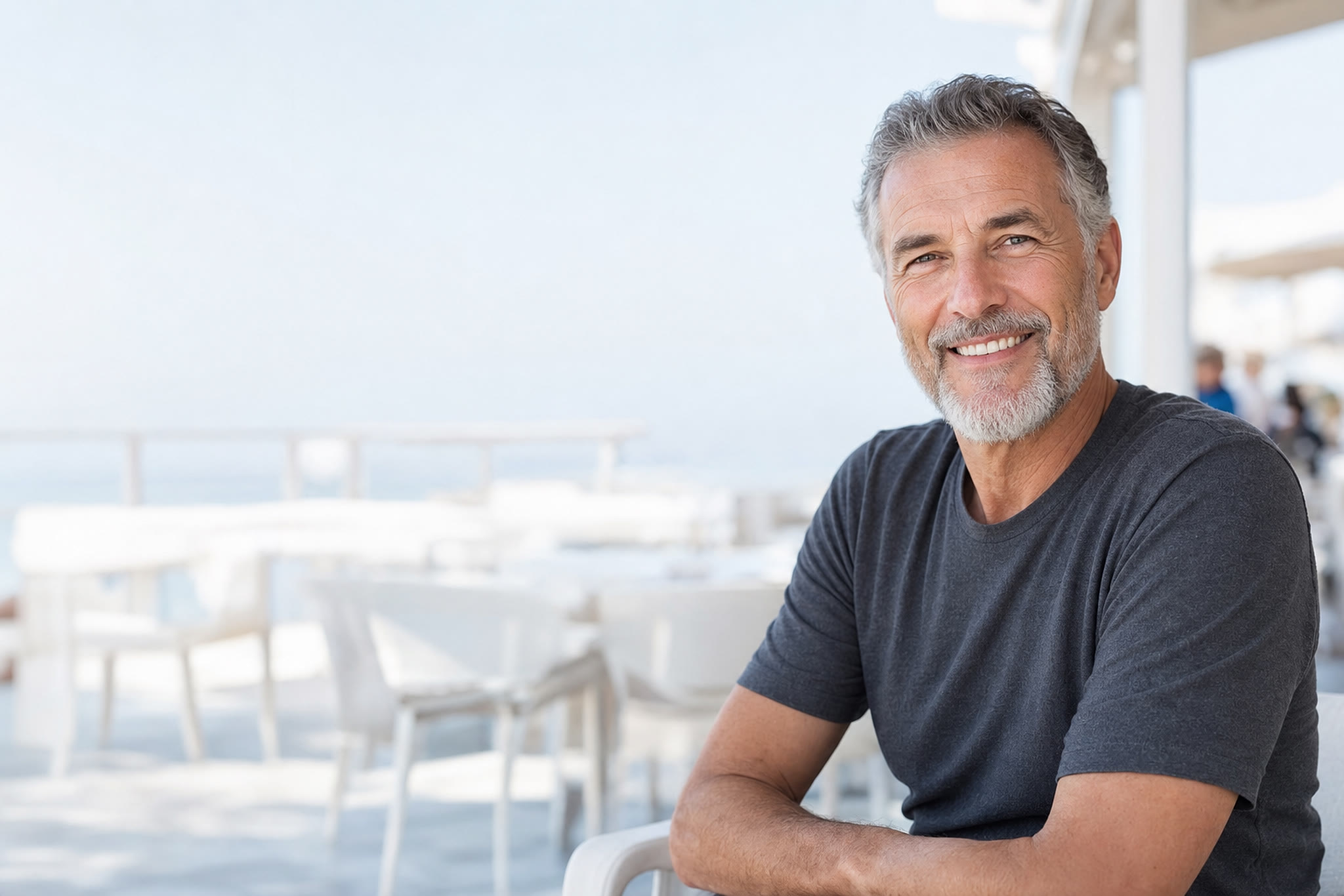Un homme souriant chaleureusement à la terrasse d’un café